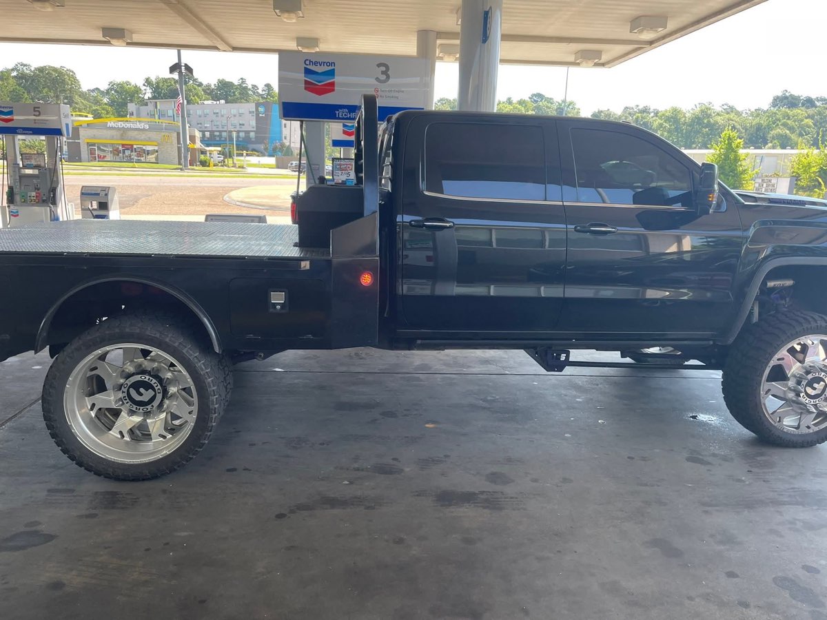 Custom lifted black diesel flatbed dually truck